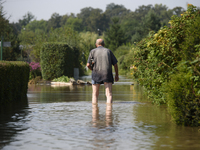 A man walks through floodwaters in the social gardens on the outskirts of Wroclaw, Poland, on September 18, 2024. The government outlines a...