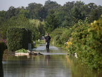 A man walks through floodwaters in the social gardens on the outskirts of Wroclaw, Poland, on September 18, 2024. The government outlines a...