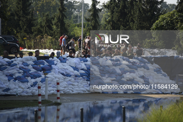 People and members of the territorial defense army fill bags with sand as they prepare for the flood wave to reach the southwestern city of...