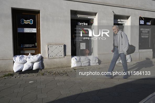 A man walks past closed shops protected by sandbags in Wroclaw, Poland, on September 18, 2024. The government outlines a reconstruction plan...