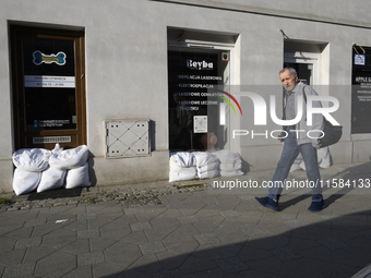 A man walks past closed shops protected by sandbags in Wroclaw, Poland, on September 18, 2024. The government outlines a reconstruction plan...