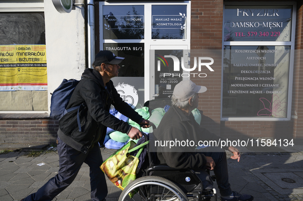 Men walk past sandbags placed outside a shop to protect it from floodwaters in Wroclaw, Poland, on September 18, 2024. The government outlin...