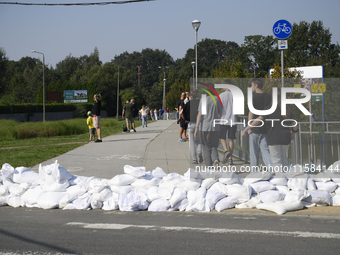 People walk past sandbags as they prepare for the flood wave to reach the southwestern city of Wroclaw, Poland, on September 18, 2024. The g...