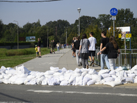 People walk past sandbags as they prepare for the flood wave to reach the southwestern city of Wroclaw, Poland, on September 18, 2024. The g...