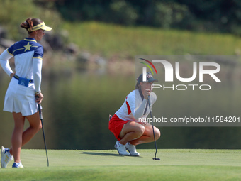 GAINESVILLE, VIRGINIA - SEPTEMBER 15: Jennifer Kupcho of the United States lines up her putt on the 11th green as Linn Grant of Team Europe...