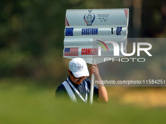 GAINESVILLE, VIRGINIA - SEPTEMBER 15: The standard bearer carries the sign displaying the score for Madelene Sagstrom of Team Europe versus...