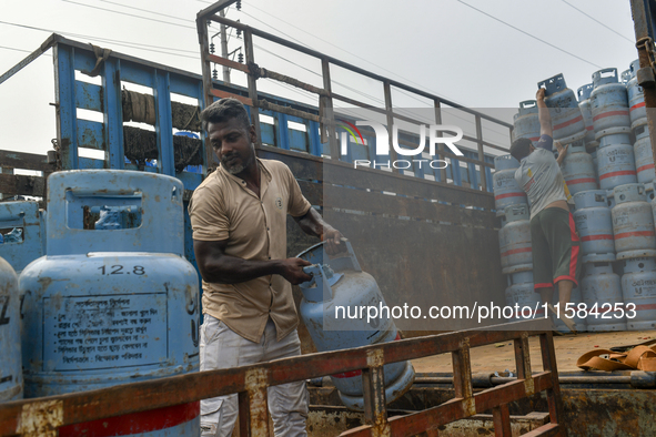 Laborers unload filled gas cylinders from a truck in Dhaka, Bangladesh, on September 18, 2024. 