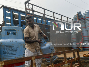 Laborers unload filled gas cylinders from a truck in Dhaka, Bangladesh, on September 18, 2024. (