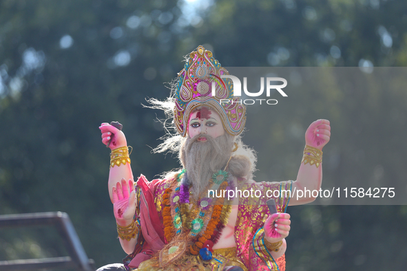 An eco-friendly idol of the Nepali Hindu god Bishwokarma is pictured on top of a vehicle as it is taken for immersion into the Bagmati River...