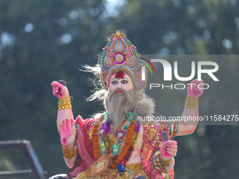 An eco-friendly idol of the Nepali Hindu god Bishwokarma is pictured on top of a vehicle as it is taken for immersion into the Bagmati River...