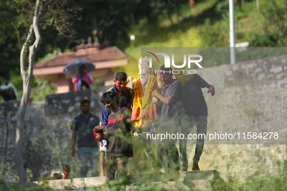 Nepali Hindu devotees carry an eco-friendly idol of Lord Bishwokarma to immerse it in the Bagmati River in Kathmandu, Nepal, on September 18...