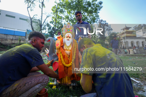 Nepali Hindu devotees perform rituals before they immerse an eco-friendly idol of the Hindu god Bishwokarma in the Bagmati River in Kathmand...