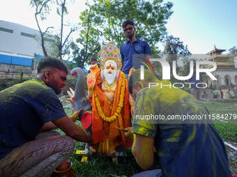 Nepali Hindu devotees perform rituals before they immerse an eco-friendly idol of the Hindu god Bishwokarma in the Bagmati River in Kathmand...