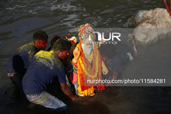 Nepali Hindu devotees immerse the eco-friendly idol of Lord Bishwokarma in the Bagmati River in Kathmandu, Nepal, on September 18, 2024. Bis...