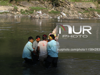 Nepali Hindu devotees immerse the eco-friendly idol of Lord Bishwokarma in the Bagmati River in Kathmandu, Nepal, on September 18, 2024. Bis...