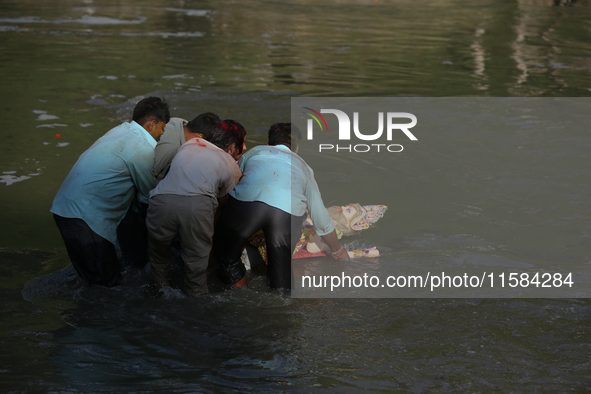 Nepali Hindu devotees immerse the eco-friendly idol of Lord Bishwokarma in the Bagmati River in Kathmandu, Nepal, on September 18, 2024. Bis...