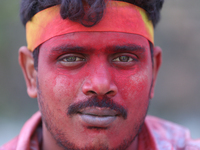 A Nepali Hindu devotee's face is smeared with vermillion powder as he takes part in the immersion ceremony of eco-friendly Lord Bishwokarma...