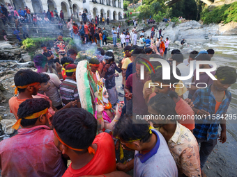 Nepali Hindu devotees perform rituals before they immerse an eco-friendly idol of the Hindu god Bishwokarma in the Bagmati River in Kathmand...