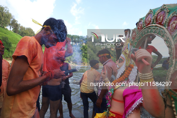 Nepali Hindu devotees perform rituals before they immerse an eco-friendly idol of the Hindu god Bishwokarma in the Bagmati River in Kathmand...