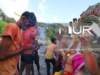 Nepali Hindu devotees perform rituals before they immerse an eco-friendly idol of the Hindu god Bishwokarma in the Bagmati River in Kathmand...