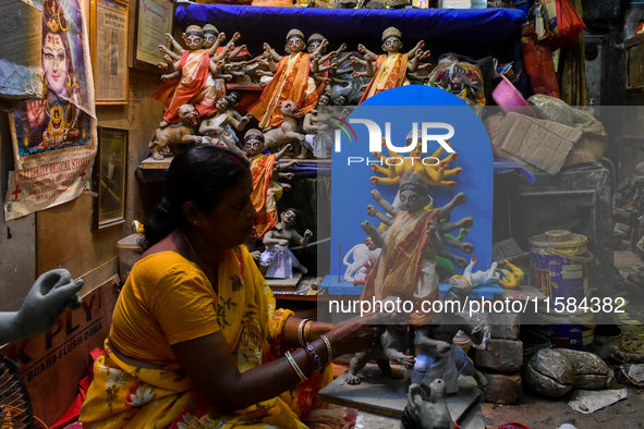 A female artist gives final touches to an idol of goddess Durga ahead of the Durga Puja festival at her workshop in Kolkata, India, on Septe...