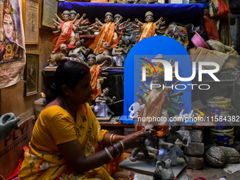 A female artist gives final touches to an idol of goddess Durga ahead of the Durga Puja festival at her workshop in Kolkata, India, on Septe...