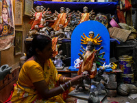 A female artist gives final touches to an idol of goddess Durga ahead of the Durga Puja festival at her workshop in Kolkata, India, on Septe...