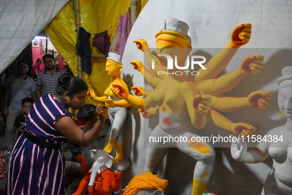 A female artist gives final touches to an idol of goddess Durga ahead of the Durga Puja festival at her workshop in Kolkata, India, on Septe...