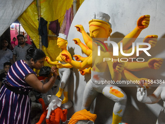 A female artist gives final touches to an idol of goddess Durga ahead of the Durga Puja festival at her workshop in Kolkata, India, on Septe...