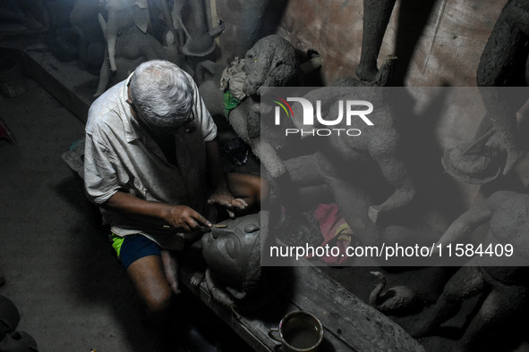 An artist makes the head of an idol ahead of the Durga Puja festival at a potters' hub in Kolkata, India, on September 18, 2024. 