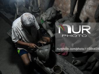 An artist makes the head of an idol ahead of the Durga Puja festival at a potters' hub in Kolkata, India, on September 18, 2024. (