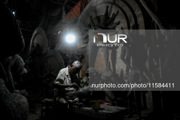 An artist makes the head of an idol ahead of the Durga Puja festival at a potters' hub in Kolkata, India, on September 18, 2024. 