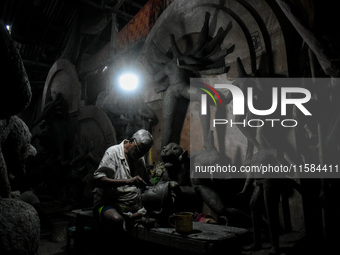 An artist makes the head of an idol ahead of the Durga Puja festival at a potters' hub in Kolkata, India, on September 18, 2024. (