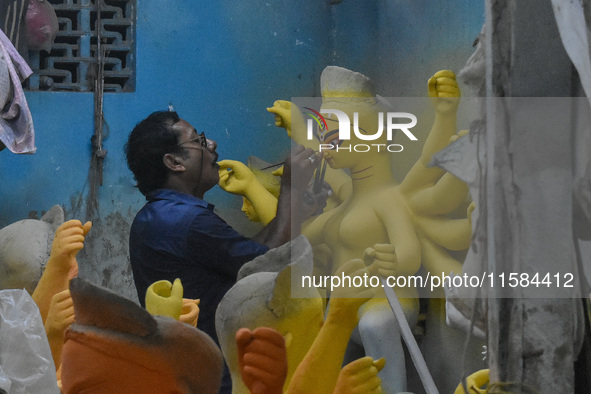 An artist gives final touches to an idol of goddess Durga ahead of the Durga Puja festival at a workshop in Kolkata, India, on September 18,...