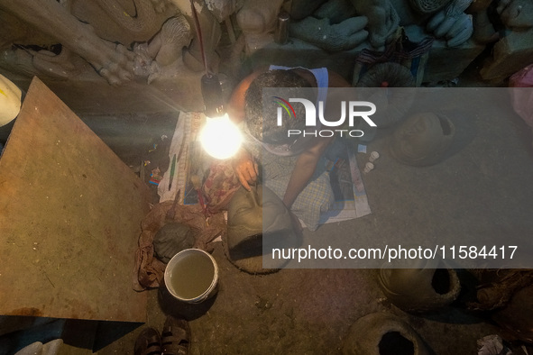 An artist makes the head of an idol ahead of the Durga Puja festival at a potters' hub in Kolkata, India, on September 18, 2024. 