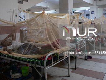 Dengue patients lie inside mosquito nets at Mugda Medical College and Hospital in Dhaka, Bangladesh, on September 18, 2024. (