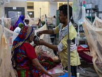 Rina Begum (70) drinks juice from her son's hand as she is admitted to the hospital due to dengue fever in Dhaka, Bangladesh, on September 1...