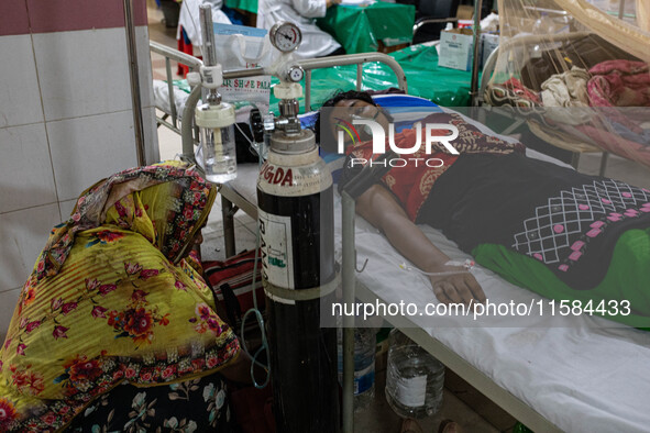 Jannatul Fedaus Maya (17), a dengue patient with breathing problems, receives oxygen support at Mugda Medical College and Hospital 