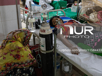 Jannatul Fedaus Maya (17), a dengue patient with breathing problems, receives oxygen support at Mugda Medical College and Hospital (