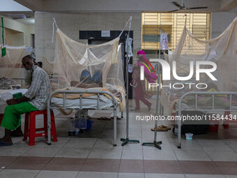 Dengue patients lie inside mosquito nets at Mugda Medical College and Hospital in Dhaka, Bangladesh, on September 18, 2024. (