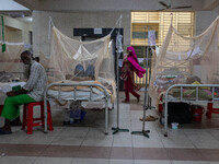 Dengue patients lie inside mosquito nets at Mugda Medical College and Hospital in Dhaka, Bangladesh, on September 18, 2024. (