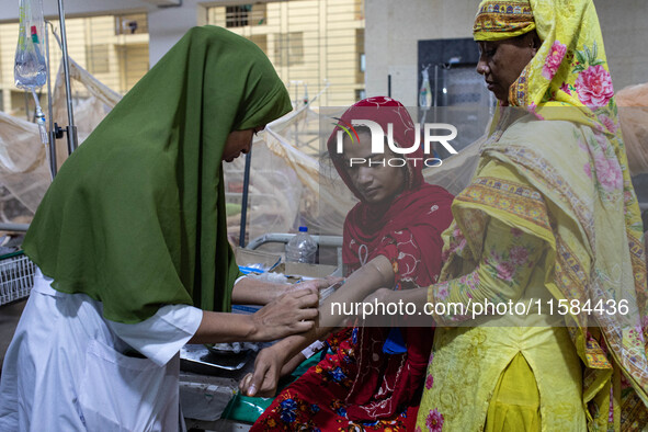 Shikha (18), a dengue patient, gives a blood sample for further tests. Jannatul Fedaus Maya (17), a dengue patient with breathing problems,...