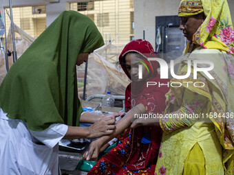 Shikha (18), a dengue patient, gives a blood sample for further tests. Jannatul Fedaus Maya (17), a dengue patient with breathing problems,...