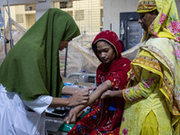 Shikha (18), a dengue patient, gives a blood sample for further tests. Jannatul Fedaus Maya (17), a dengue patient with breathing problems,...