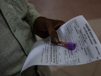 An attendant of a dengue patient submits a blood sample to the lab while Jannatul Fedaus Maya (17), a dengue patient with breathing problems...