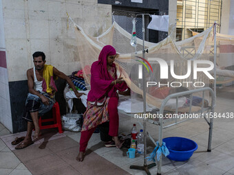 Dengue patients lie inside mosquito nets at Mugda Medical College and Hospital in Dhaka, Bangladesh, on September 18, 2024. (