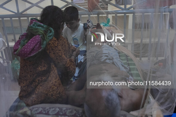 Dengue patients lie inside mosquito nets at Mugda Medical College and Hospital in Dhaka, Bangladesh, on September 18, 2024. 