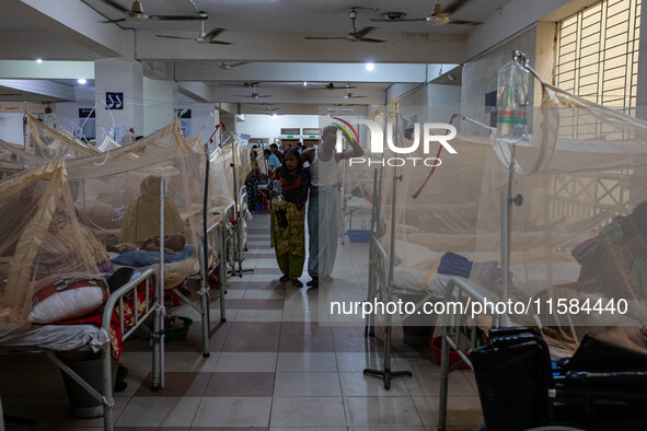 A dengue patient walks back to his bed from the nurse station after receiving necessary treatment at Mugda Medical College and Hospital in D...