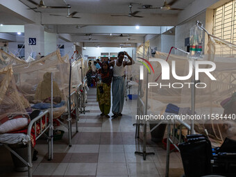 A dengue patient walks back to his bed from the nurse station after receiving necessary treatment at Mugda Medical College and Hospital in D...