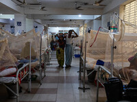 A dengue patient walks back to his bed from the nurse station after receiving necessary treatment at Mugda Medical College and Hospital in D...